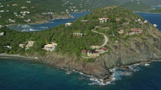 AX103_035E - 4.8K aerial stock footage of oceanfront homes and hillside mansions along sapphire blue waters, Cruz Bay, St John