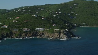 AX103_037 - 4.8K aerial stock footage of Hillside mansions overlooking Caribbean blue waters, Cruz Bay, St John