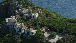AX103_038E - 4.8K aerial stock footage of hilltop mansion with a sapphire blue ocean view, Cruz Bay, St John