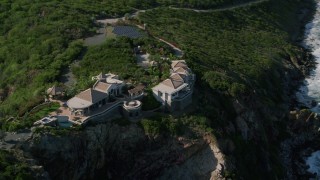 AX103_040 - 4.8K aerial stock footage of a Cliff top mansion and Caribbean blue ocean view, Cruz Bay, St John