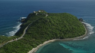 AX103_043 - 4.8K aerial stock footage of a Cliff top mansion among trees and sapphire blue Caribbean waters, Cruz Bay, St John