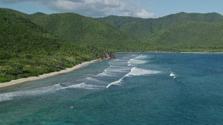 AX103_044E - 4.8K aerial stock footage of a Caribbean beach along sapphire blue waters and tree covered hills, Reef Bay, St John