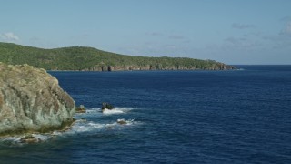 AX103_050E - 4.8K aerial stock footage of coastal cliffs along sapphire blue Caribbean waters, Central, St John
