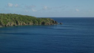 AX103_056 - 4.8K aerial stock footage of a Tree covered rugged coast along blue waters of Great Lameshur Bay, St John