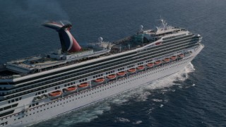 AX103_070 - 4.8K aerial stock footage of a Carnival cruise ship in sapphire blue Caribbean waters, St Thomas