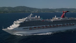 AX103_072 - 4.8K aerial stock footage of a Carnival cruise ship in Caribbean blue waters, St Thomas