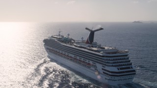 AX103_073 - 4.8K aerial stock footage of Carnival cruise ship in Caribbean blue waters, St Thomas