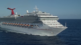 AX103_073E - 4.8K aerial stock footage of Carnival cruise ship in Caribbean blue waters, St Thomas