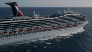 AX103_074 - 4.8K aerial stock footage of a Carnival cruise ship in Caribbean blue waters, St Thomas