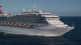 AX103_075 - 4.8K aerial stock footage of a Carnival cruise ship in Caribbean blue waters off the coast, St Thomas
