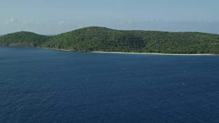 AX103_095 - 4.8K aerial stock footage of Vegetation covered island along sapphire blue Caribbean waters, Cayo Norte, Puerto Rico