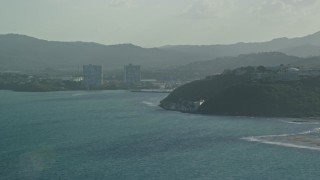 AX103_116 - 4.8K aerial stock footage of a Coastal town along Caribbean blue waters, Fajardo, Puerto Rico