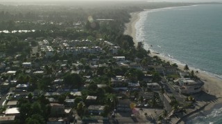 AX103_133E - 4.8K aerial stock footage of beachfront homes and Caribbean beach along blue waters, Loiza, Puerto Rico