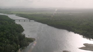 AX103_136 - 4.8K aerial stock footage of a Bridge over a river surrounded by vegetation, Loiza, Puerto Rico