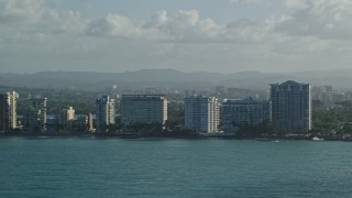 AX103_147E - 4.8K aerial stock footage of condominiums along Caribbean blue waters, Carolina, Puerto Rico
