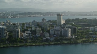 AX103_151E - 4.8K aerial stock footage of apartment buildings by Caribbean blue waters, San Juan, Puerto Rico