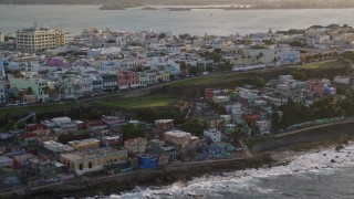 AX104_003 - 4.8K aerial stock footage of Oceanfront Caribbean homes, Old San Juan, Puerto Rico, sunset