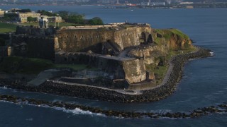 AX104_005 - 4.8K aerial stock footage of Fort San Felipe del Morro, Old San Juan, sunset