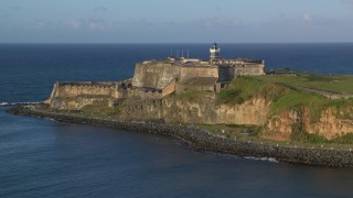 AX104_008 - 4.8K aerial stock footage of Fort San Felipe del Morro, Old San Juan, sunset