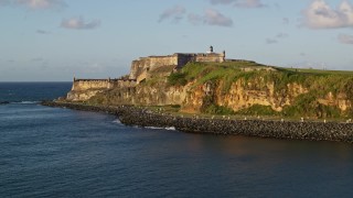 AX104_009E - 4.8K aerial stock footage of Fort San Felipe del Morro, Old San Juan, sunset
