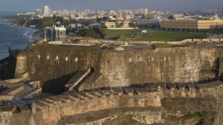 AX104_017 - 4.8K aerial stock footage of Fort San Felipe del Morro and lighthouse, Old San Juan, sunset
