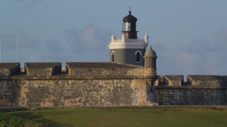 AX104_023 - 4.8K aerial stock footage of Port San Juan Light and Fort San Felipe del Morro, Old San Juan, sunset