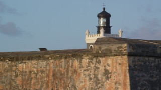 AX104_024 - 4.8K aerial stock footage of Port San Juan Light and Fort San Felipe del Morro, Old San Juan, sunset