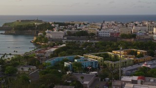 AX104_034E - 4.8K aerial stock footage of La Fortaleza among Caribbean buildings, Old San Juan, sunset