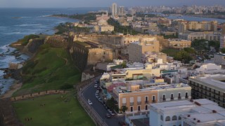 AX104_044 - 4.8K aerial stock footage of Fort San Cristobal along the ocean, Old San Juan sunset