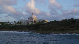 AX104_046 - 4.8K aerial stock footage of Oceanfront San Juan Capitol Building, Old San Juan Puerto Rico, sunset