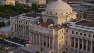 AX104_046E - 4.8K aerial stock footage of oceanfront San Juan Capitol Building, Old San Juan Puerto Rico, sunset