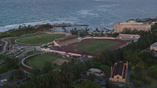 AX104_057 - 4.8K stock footage aerial video of Estadio Sixto Escobar stadium oceanside, San Juan, Puerto Rico, sunset