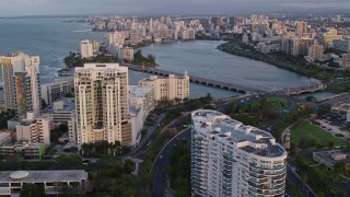 AX104_058 - 4.8K aerial stock footage of Avenida Ashford bridge and high-rises, San Juan, Puerto Rico, sunset