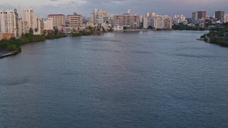 AX104_060 - 4.8K aerial stock footage of hotels along Condado Lagoon, San Juan, Puerto Rico sunset