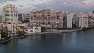 AX104_061 - 4.8K aerial stock footage of Hotels along Caribbean blue waters, San Juan, Puerto Rico sunset