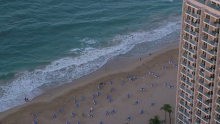 AX104_064 - 4.8K aerial stock footage of a Marriott hotel, Caribbean beach and turquoise waters San Juan, Puerto Rico sunset
