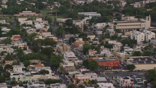 AX104_068 - 4.8K aerial stock footage of Beachfront hotels and ocean waters, San Juan, Puerto Rico, sunset