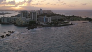 AX104_072 - 4.8K aerial stock footage of the Oceanfront Caribe Hilton Hotel, Normandie Hotel, San Juan, Puerto Rico, sunset