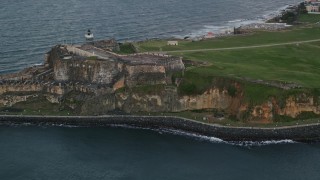 AX104_085 - 4.8K aerial stock footage of Fort San Felipe del Morro and Caribbean blue ocean waters, Old San Juan, twilight