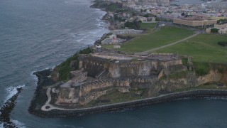 AX104_089 - 4.8K aerial stock footage of Fort San Felipe del Morro, Old San Juan, twilight