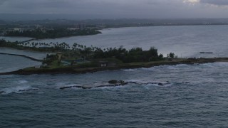 AX104_092 - 4.8K aerial stock footage of Isla de Cabras and waves along the coast, San Juan, twilight