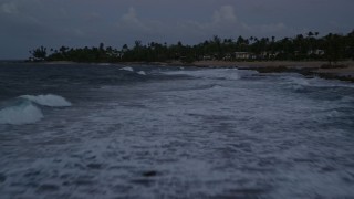 AX104_132E - 4.8K aerial stock footage of breakwaters along Caribbean coastline, Dorado, Puerto Rico, twilight