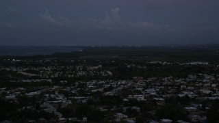 AX104_135E - 4.8K aerial stock footage ascend from the coast to reveal Caribbean town, Dorado, Puerto Rico, sunset