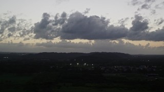 AX104_138 - 4.8K aerial stock footage of clouds over the Caribbean town of Dorado, Puerto Rico, twilight