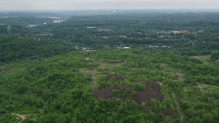 AX105_001 - 4.8K aerial stock footage of dirt roads on a green hill, Penn Hills, Pennsylvania