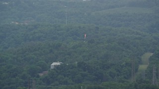 AX105_021 - 4.8K aerial stock footage of a flame spout and green trees, West Mifflin, Pennsylvania