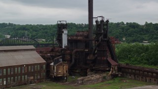 AX105_040E - 4.8K aerial stock footage orbiting a steel factory, Carrie Furnace, Pittsburgh, Pennsylvania