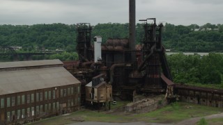 AX105_042 - 4.8K aerial stock footage orbiting a steel factory, Carrie Furnace, Pittsburgh, Pennsylvania