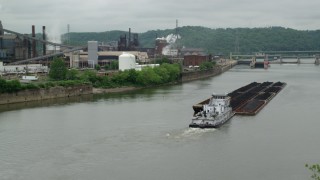 AX105_053 - 4.8K aerial stock footage of River Barge near U.S. Steel Mon Valley Works, Braddock, Pennsylvania