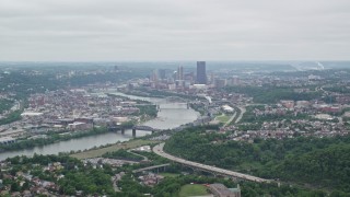 AX105_075E - 4.8K aerial stock footage tilting up from homes to reveal skyscrapers, Downtown Pittsburgh, Pennsylvania